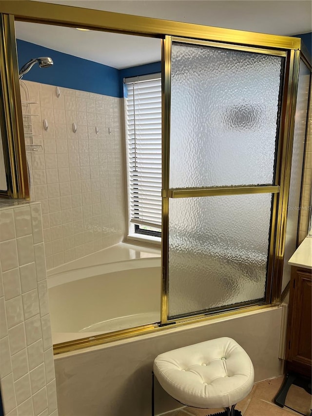 bathroom featuring tile patterned floors, shower / bath combination with glass door, and vanity