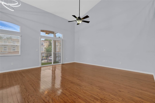 empty room featuring hardwood / wood-style floors, high vaulted ceiling, and ceiling fan