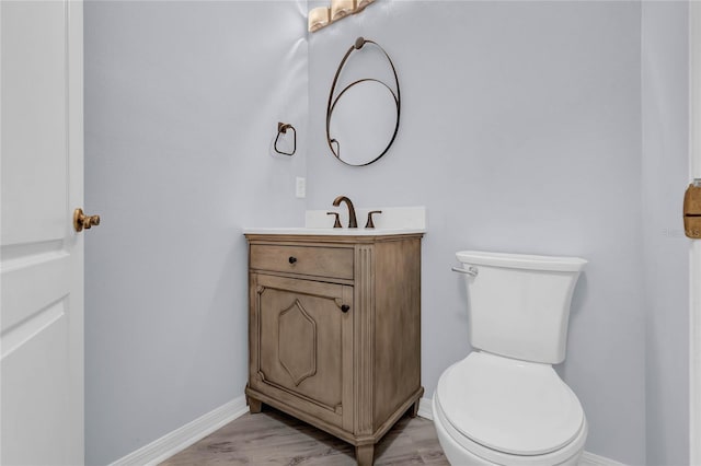 bathroom featuring hardwood / wood-style flooring, vanity, and toilet