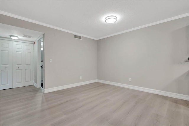 unfurnished room featuring hardwood / wood-style flooring, ornamental molding, and a textured ceiling