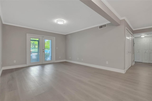 spare room featuring wood-type flooring, crown molding, and french doors