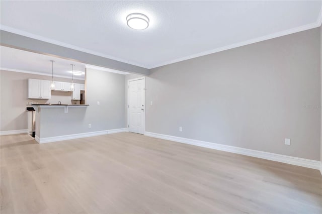 unfurnished living room featuring crown molding and light wood-type flooring