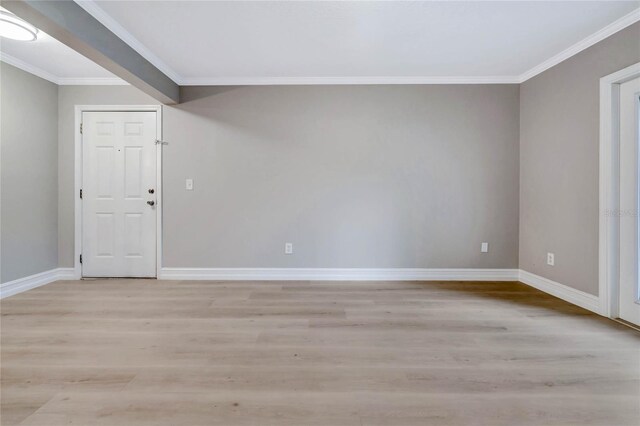 spare room with ornamental molding and light wood-type flooring