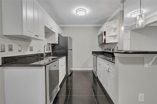 kitchen featuring white cabinetry, stainless steel appliances, hanging light fixtures, and dark tile patterned floors