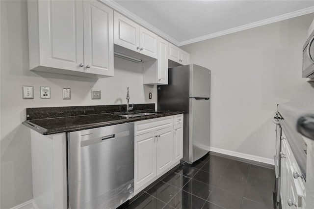 kitchen featuring dark stone counters, white cabinetry, dark tile patterned floors, sink, and appliances with stainless steel finishes