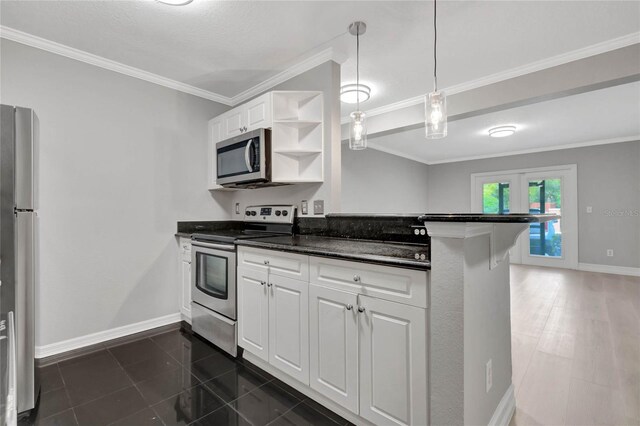 kitchen with dark tile patterned floors, white cabinetry, kitchen peninsula, appliances with stainless steel finishes, and decorative light fixtures