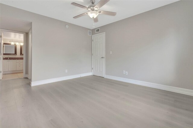 spare room featuring hardwood / wood-style floors, sink, and ceiling fan