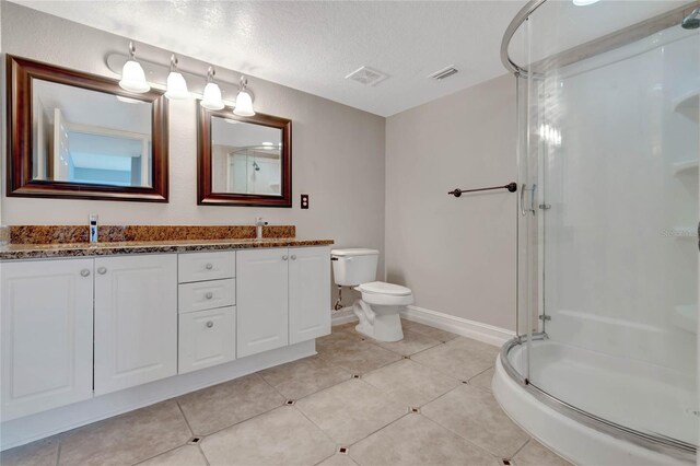 bathroom featuring toilet, a textured ceiling, double sink vanity, and tile patterned flooring