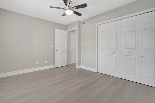 unfurnished bedroom with light wood-style floors, baseboards, visible vents, and a closet