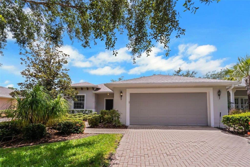 316 Shelbourne Loop, Kissimmee, FL 34759 - ranch-style home featuring a garage, decorative driveway, and stucco siding