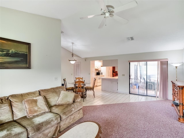 carpeted living room with ceiling fan and vaulted ceiling