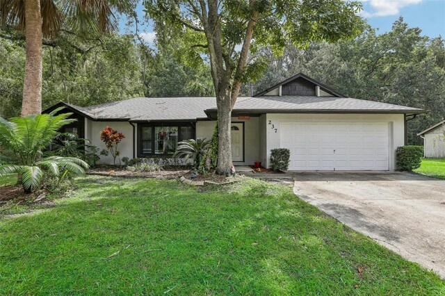 single story home featuring a front lawn and a garage