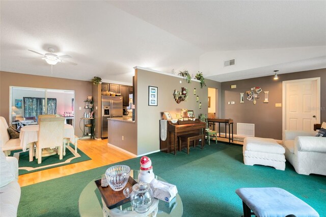 living room featuring lofted ceiling, carpet flooring, and ceiling fan