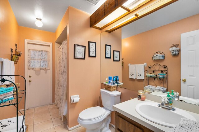 bathroom featuring vanity, tile patterned flooring, and toilet