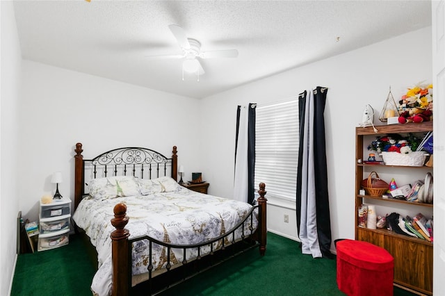 bedroom with a textured ceiling, dark colored carpet, and ceiling fan