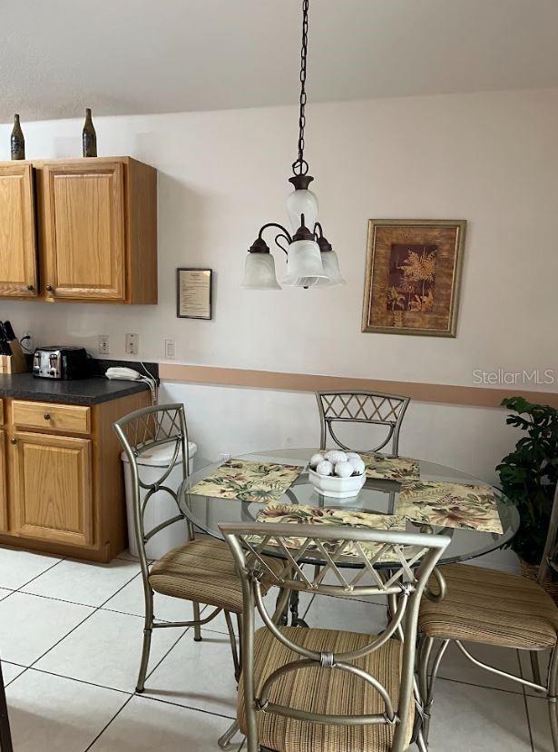 dining space with light tile patterned flooring and a chandelier