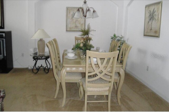 dining space with carpet and a chandelier