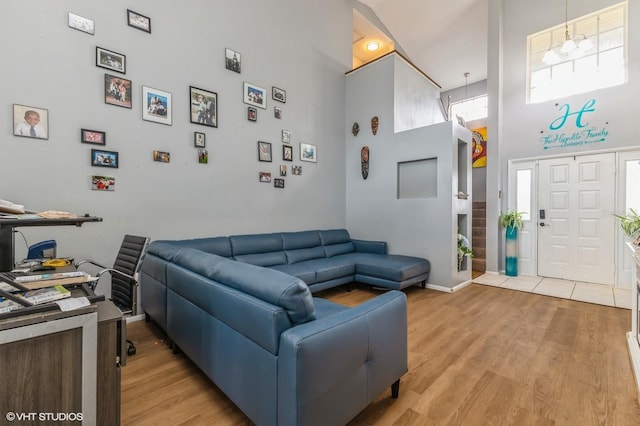 living room with a towering ceiling and hardwood / wood-style flooring