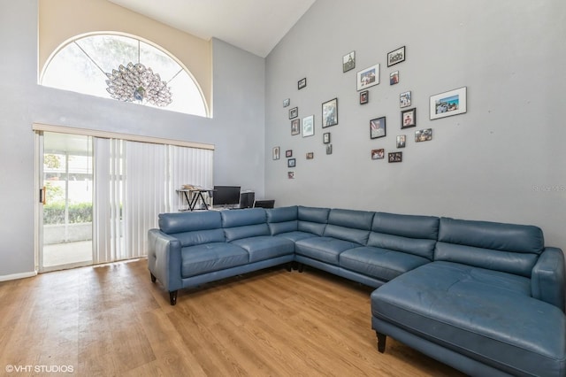 living room with high vaulted ceiling and light hardwood / wood-style flooring