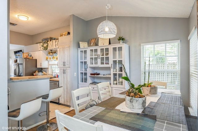 dining space featuring a wealth of natural light and a textured ceiling