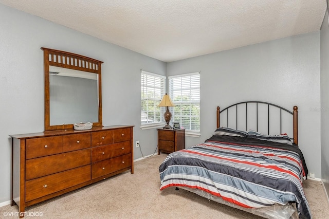 bedroom with a textured ceiling, baseboards, and light carpet