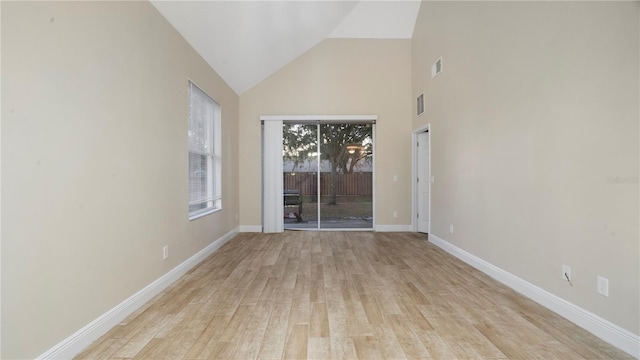 empty room with light wood-type flooring and lofted ceiling