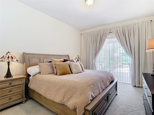 carpeted bedroom with lofted ceiling and access to exterior