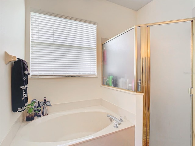 bathroom featuring plenty of natural light and plus walk in shower