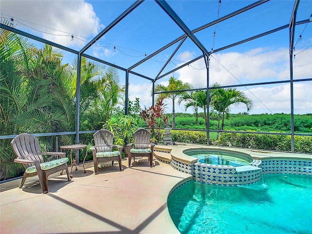 view of swimming pool with an in ground hot tub, a patio, and glass enclosure