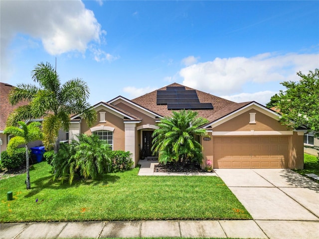 view of front of property with a garage, a front lawn, and solar panels