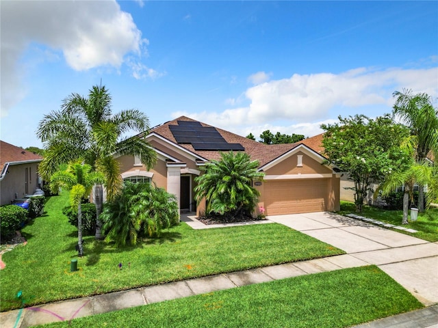 view of front of property with a garage, solar panels, and a front lawn