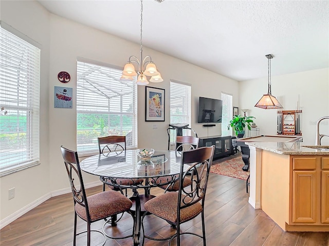 dining area with a notable chandelier and hardwood / wood-style floors