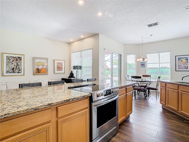 kitchen featuring dark hardwood / wood-style flooring, stainless steel electric range, a wealth of natural light, and light stone counters