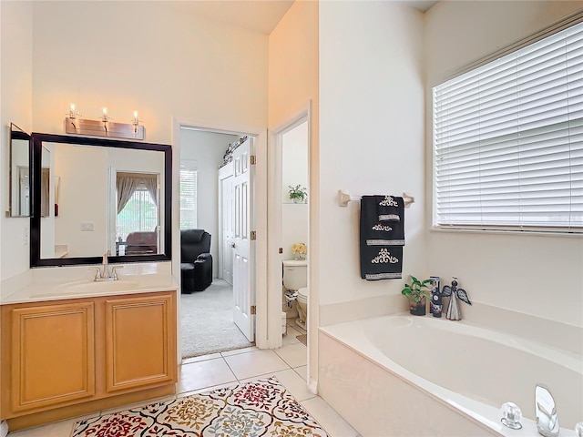 bathroom featuring vanity, tile patterned floors, a bath, and toilet