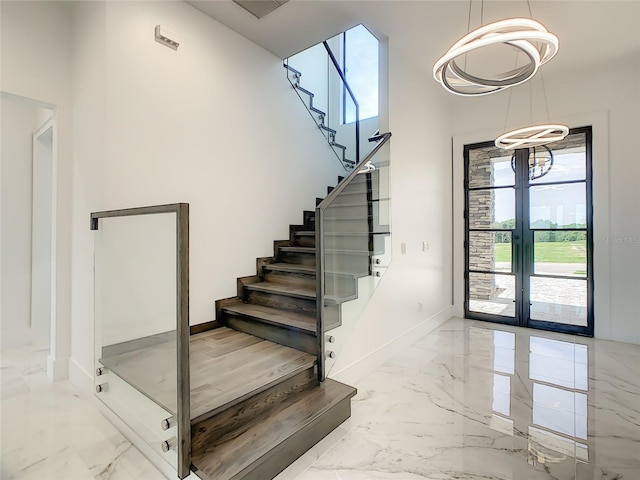 staircase featuring a high ceiling, light tile patterned floors, and french doors