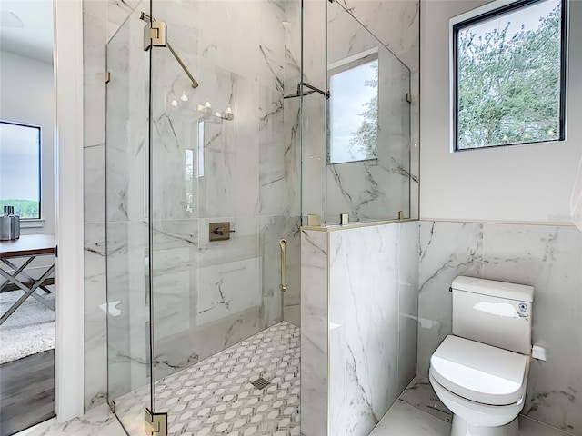 bathroom with plenty of natural light, a shower with shower door, and tile walls