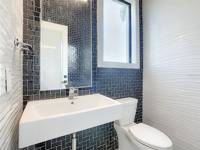 bathroom with tile walls and toilet