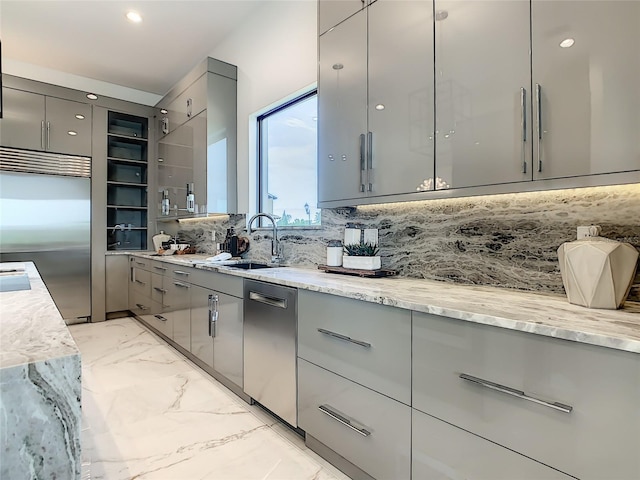 kitchen featuring sink, tasteful backsplash, light stone countertops, and gray cabinets