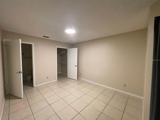 1073 S Hiawassee Rd Unit 1018, Orlando, FL 32835 - unfurnished bedroom with light tile patterned floors, a textured ceiling, visible vents, and baseboards