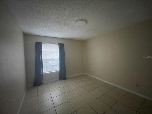 1073 S Hiawassee Rd Unit 1018, Orlando, FL 32835 - unfurnished room with light tile patterned floors, a textured ceiling, and baseboards