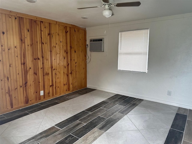 tiled empty room featuring ceiling fan, wooden walls, and a wall unit AC