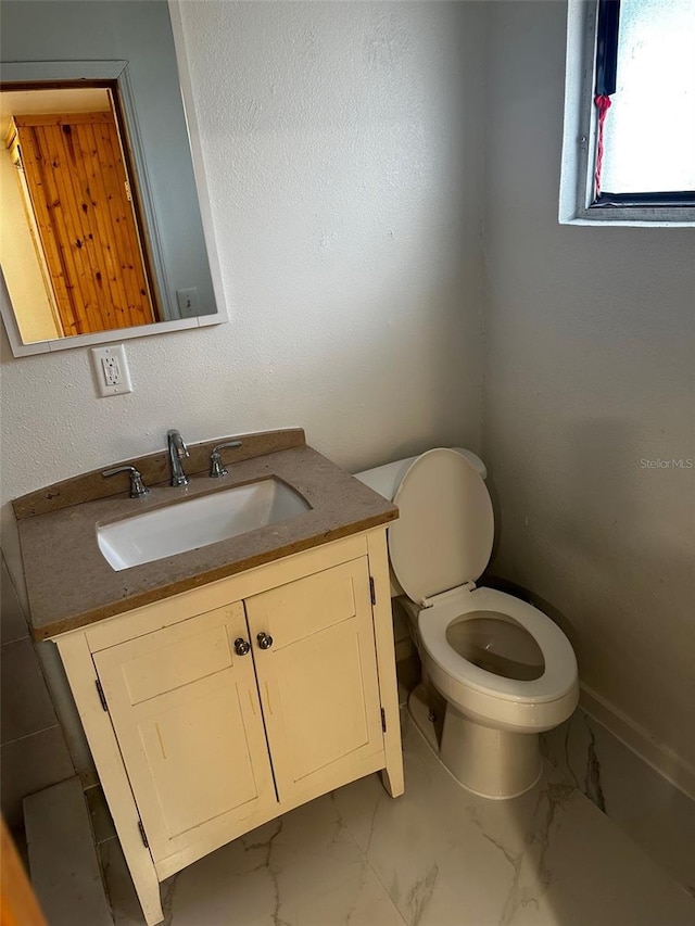 bathroom featuring tile patterned floors, vanity, and toilet