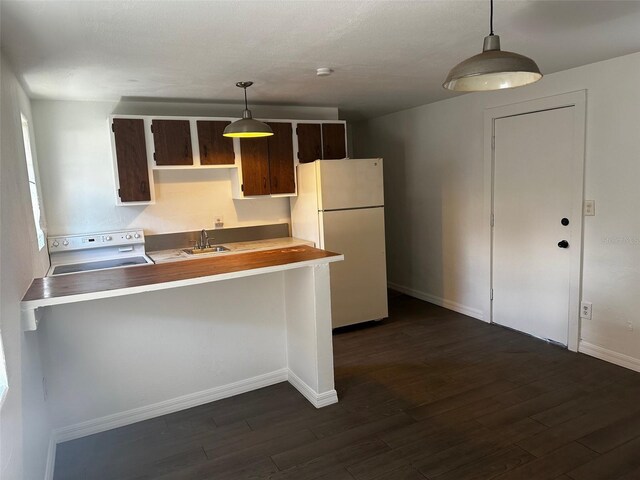 kitchen featuring white appliances, hanging light fixtures, dark hardwood / wood-style flooring, and dark brown cabinets