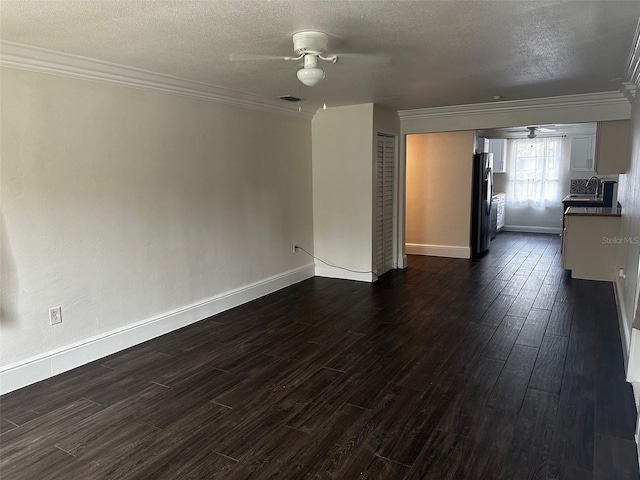 unfurnished living room with ceiling fan, dark hardwood / wood-style flooring, a textured ceiling, and crown molding