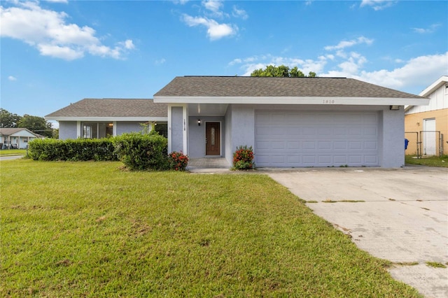 ranch-style house featuring a garage and a front lawn