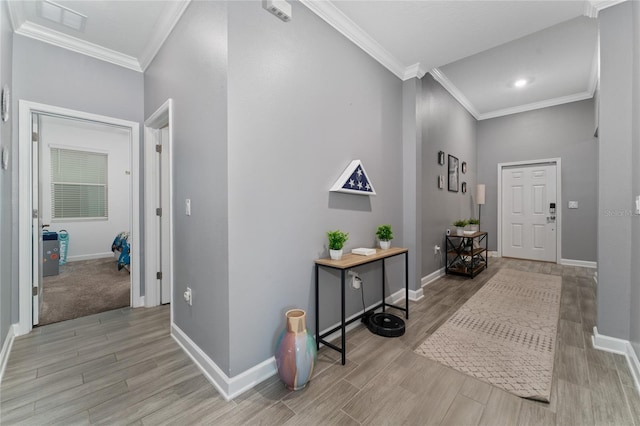 entryway with ornamental molding and light wood-type flooring