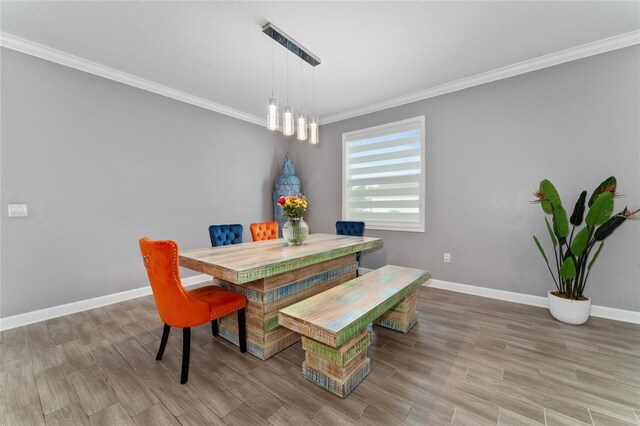 dining room with ornamental molding and light wood-type flooring