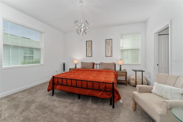 bedroom with carpet flooring, multiple windows, and a notable chandelier