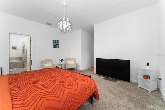 carpeted bedroom with ensuite bathroom and an inviting chandelier