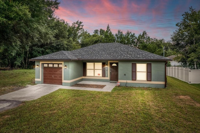 view of front of home with a garage and a lawn